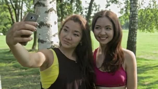 Femmes prenant selfies après des exercices de fitness dans le parc — Video