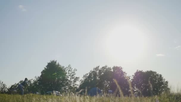 Αργή κίνηση πυροβολισμό του A νέοι κορίτσια ρίχνουν ένα πράσινο Frisbee στο καλοκαιρινή μέρα σε ψηλό λόφο — Αρχείο Βίντεο