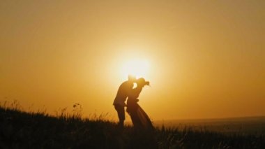 Adam romantik siluet yüksek tepe - günbatımında - öpüşme ve yavaş dans