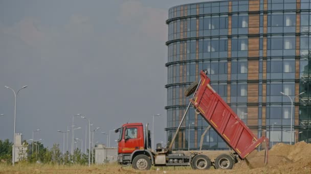 Dump truck unloading soil at construction site — Stock Video