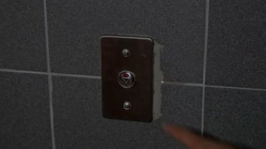 Adam bir asansörde bir düğmeye basmadan