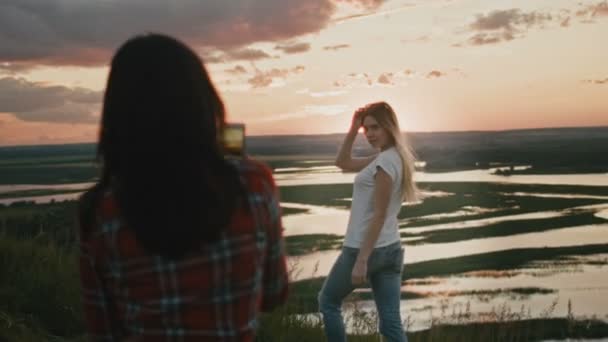 Две милые девушки привлекают молодых девушек фотографируя природу на природе за пределами Европы — стоковое видео