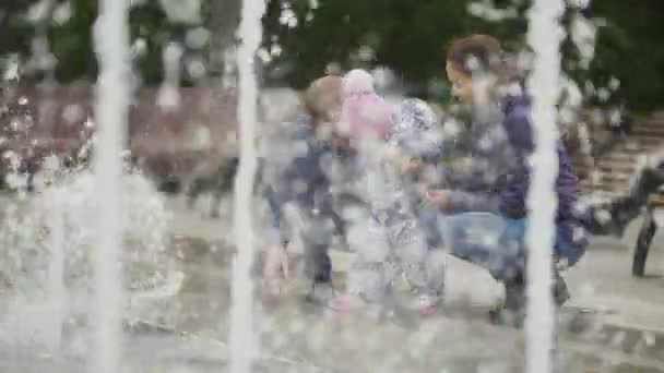 Família feliz - mãe, pai e bebê filha perto de fontes no parque da cidade - menina olhando para a água — Vídeo de Stock