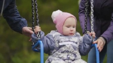 Bahçesi - baba, anne ve gülen bebek kız - çocuk salıncak, genç mutlu aileye yakın çekim