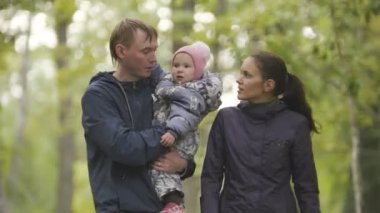 Mutlu bir aile: Baba, anne ve çocuk - sonbahar Park küçük kız: düşmüş yaprakları ile sokakta yürürken yakın çekim