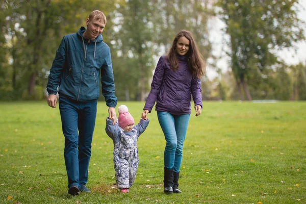 Щаслива сім'я: батько, мати і дитина - маленька дівчинка в осінньому парку: гуляти на лузі, під широким кутом — стокове фото