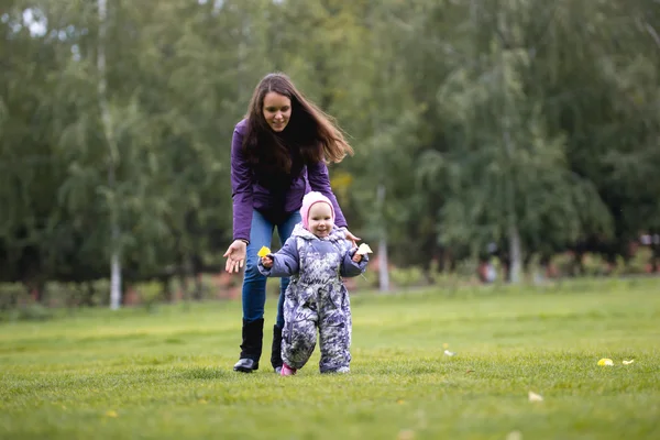 Familia feliz: Madre e hijo - niña caminando en el parque de otoño: bebé jugando en la hierba, de cerca — Foto de Stock