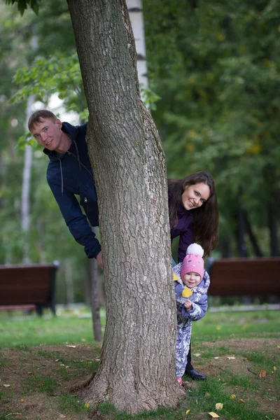 Gelukkige familie: vader, moeder en kind-klein meisje wandelen in de herfst Park: Mammy het vliegtuig spelen — Stockfoto