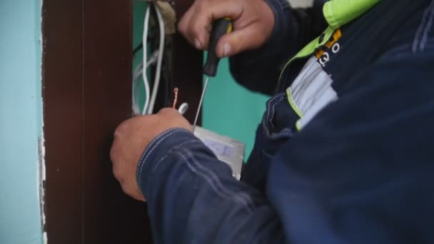 Электрик подключает коммутатор в помещении, закрывает — стоковое видео