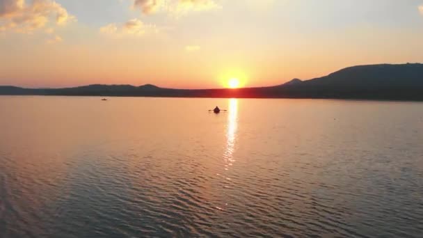 Mann segelt auf dem Boot mit Paddeln auf dem Fluss bei Sonnenuntergang - schöne Landschaft — Stockvideo