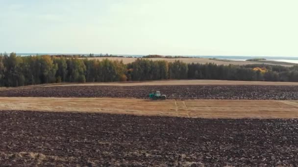 Podzimní krajina polí, oblohy a vesnice - traktory orá pole — Stock video