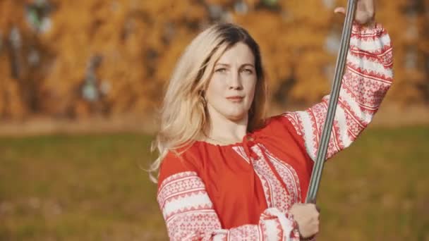 Trening na jesiennym polu - wojownicza kobieta dzierży miecze — Wideo stockowe