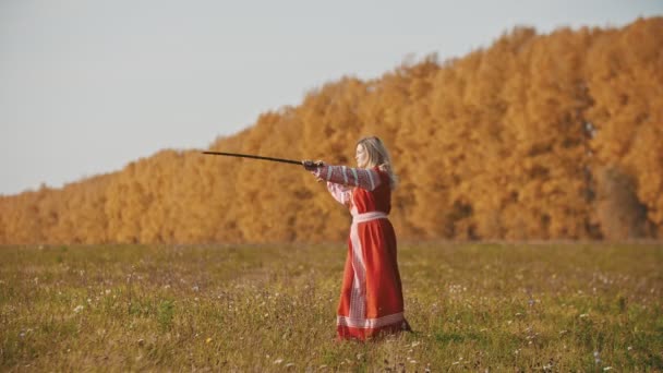 Training in het herfstveld - een strijdlustige vrouw hanteert twee zwaarden — Stockvideo