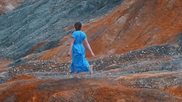 Молода жінка, яка подорожує, бігає на оранжевих глиняних горах і має мить — стокове відео