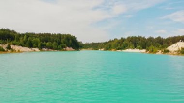 Ormanla çevrili açık mavi bir göl manzarası