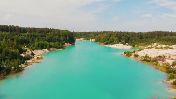 Landschaft eines hellblauen Sees, umgeben von Wald und Sandhügeln — Stockvideo