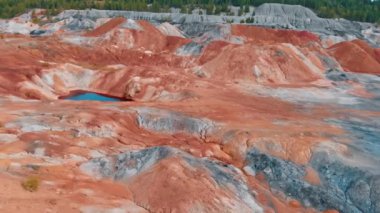 Turuncu kil bir dağın tepesinde yürüyen bir adam - kırmızı göletler etrafında