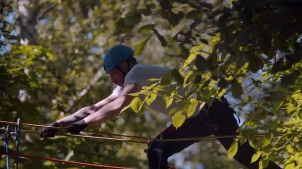 Человек ходит по подвесным мостам между деревьями на высоте — стоковое видео