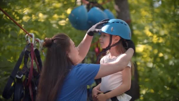 警部女性は森の中で極端な魅力の前に女の子に保護ヘルメットを置きます — ストック動画