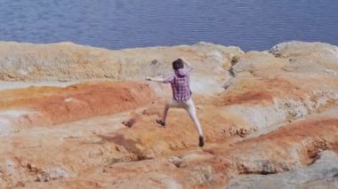 Genç adam kil dağlarda koşuyor.