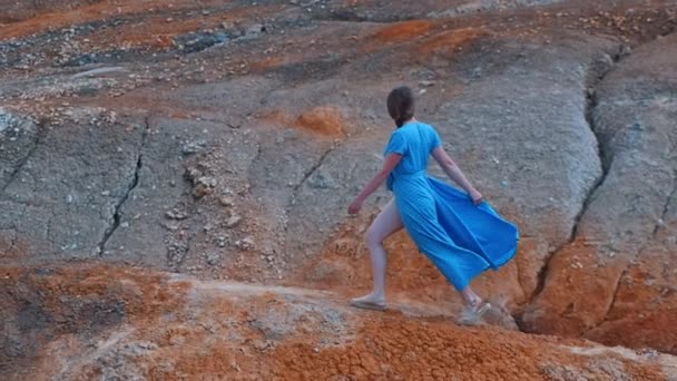 Молодая женщина путешествует по оранжевым глиняным горам — стоковое видео