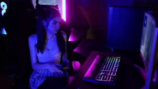 Jonge vrouw spelen een online spel in neon gaming club — Stockvideo