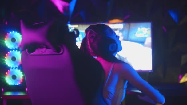 Ung kvinna spelar ett spel i gaming club - vinna rundan vänder sig om och sätta händerna upp — Stockvideo