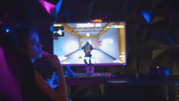 Jovem mulher jogando um jogo online no clube de jogos arrancando uma pastilha elástica da boca — Vídeo de Stock