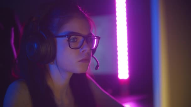 Joven bonita mujer en gafas jugando juegos en el club de juegos de neón — Vídeo de stock