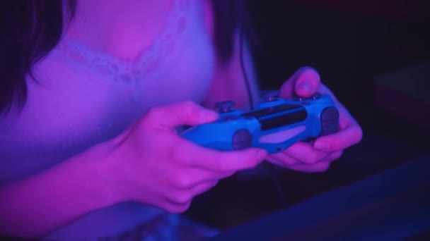 Игра в неоновые игры в клубе - женщина держит джойстик — стоковое видео