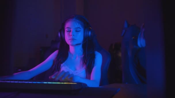Két csinos lány játszik egy online játék a neon játék klub — Stock videók