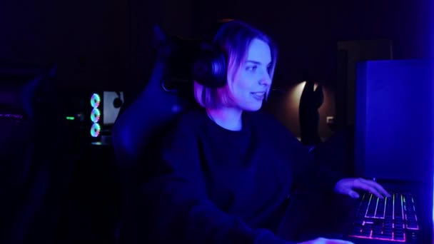 Zwei Mädchen spielen ein Online-Spiel im Neon-Gaming-Club - und geben sich gegenseitig eine hohe Fünf — Stockvideo