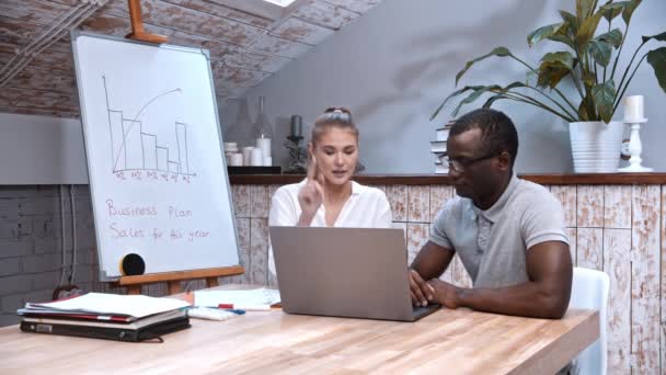 Exitoso hombre afroamericano y mujer caucásica en la reunión de negocios - mirando en el portátil y obtener emocionante — Vídeos de Stock