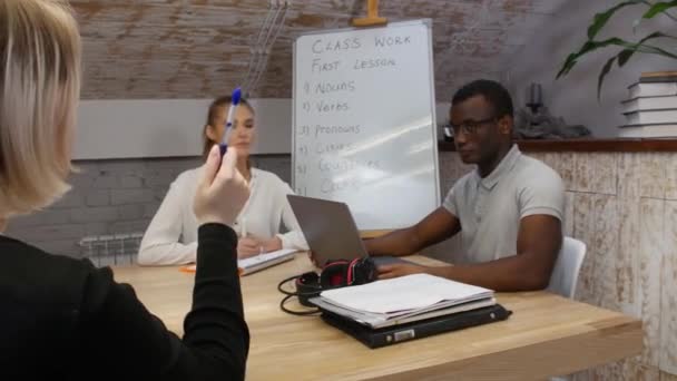 Clase de inglés - profesor que tiene una lección con una mujer y un hombre afroamericano — Vídeos de Stock