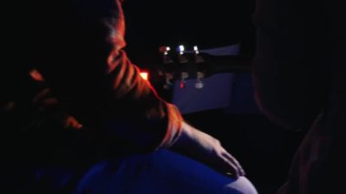 Stüdyoda gitar çalan iki adam şarkı kaydediyor.