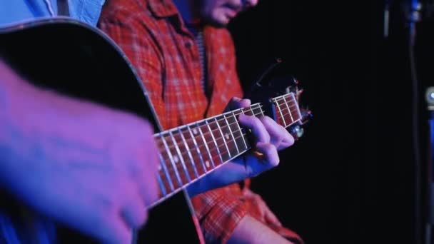 Dois homens gravando uma música indie no estúdio tocando guitarra acústica e cantando em microfone — Vídeo de Stock