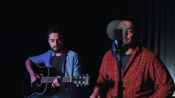 Két hipszter férfi felvesz egy indie dalt a stúdióban. — Stock videók