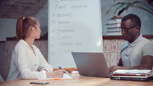 Woman and african-american man on english lesson - man pointing at the board — Stock Video