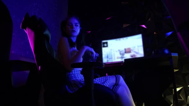Genç seksi kadın oyun kulübünde oturuyor ve ağzında sakızla oynuyor. — Stok video