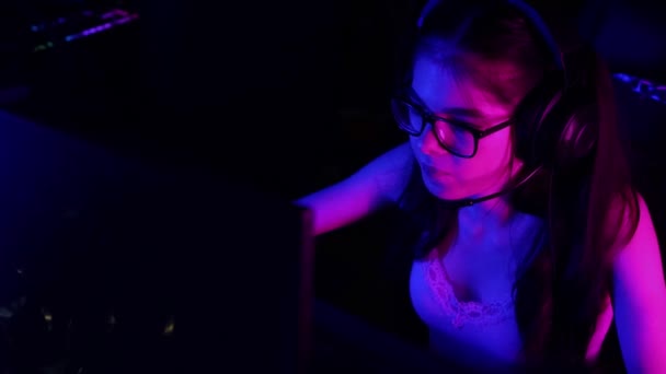 Ung attraktiv kvinde spiller et spil i gaming klub og tygge en boble tyggegummi – Stock-video