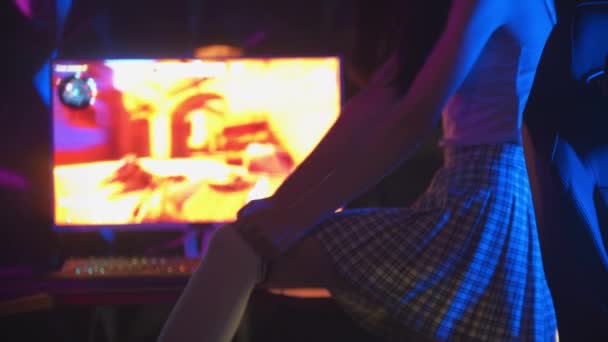 Bilgisayar kulübündeki genç seksi kadın golf çoraplarını çekip sandalyeye oturur ve kulaklık takar. — Stok video