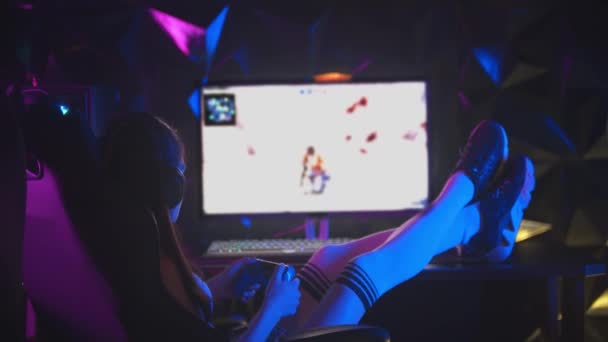 Молодая привлекательная женщина играет в игры в игорном клубе с ногами на столе — стоковое видео
