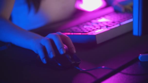 Young woman playing online games in neon gaming club - mouse and illuminated keyboard — Stock Video
