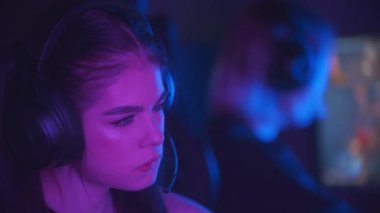 Neon oyun kulübünde oynayan iki güzel kız arkadaş. Birbirlerine beşlik çakıyorlar.