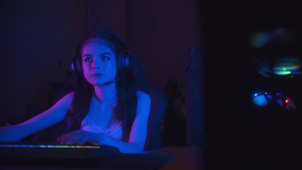 Две красивые девушки-геймеры играют в онлайн-игру в неоновом игровом клубе — стоковое видео