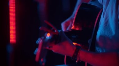 Neon ışıkta gitar çalan adam.