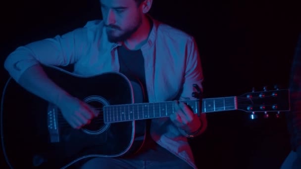 Deux hommes assis dans un studio sombre et enregistrant une chanson avec guitare — Video