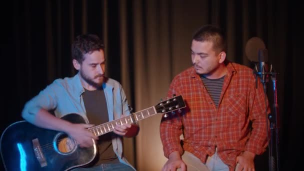 스튜디오에서 기타 노래를 녹음하고 있는 두 남자 — 비디오