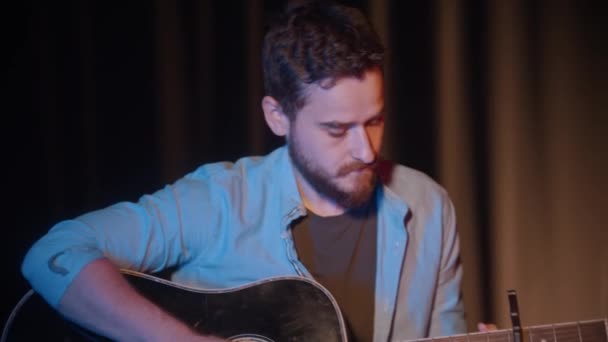 Conceito de músico - homem barbudo tocando guitarra com um capo — Vídeo de Stock