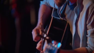 İki adam sahnede oturup şarkı söylüyor.